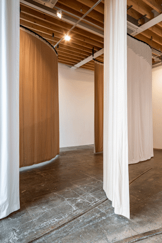 Brown and white curtains in a wavy shape as a part of Art installation in Tramway as part of Glasgow International 2018.