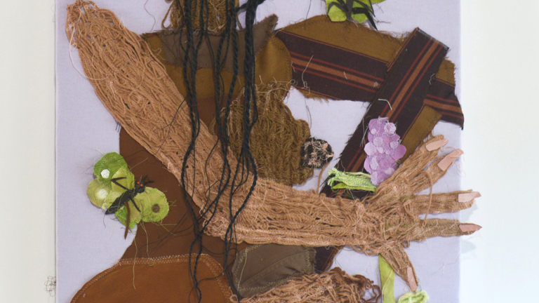 Textile portrait of a Black woman holding a lilac flower blossom. Two green butterflies with small orange eyes rest on her arm and move through her braids. The woman, constructed from found fabric, sits cross-legges with her head tilted and a slight smile. 