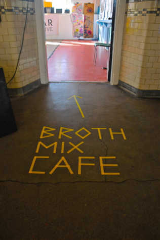 In the hallway leading to a room, the floor has the words "Broth Mix Cafe" and an arrow pointing to the room stuck to the floor.