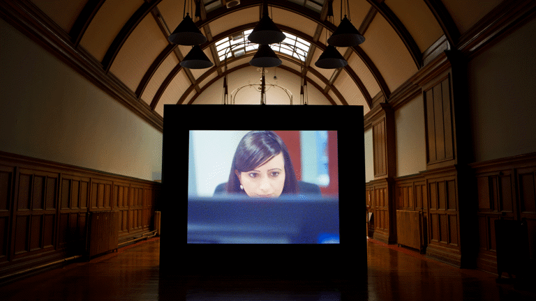 a person looks at a computer screen in a projected film