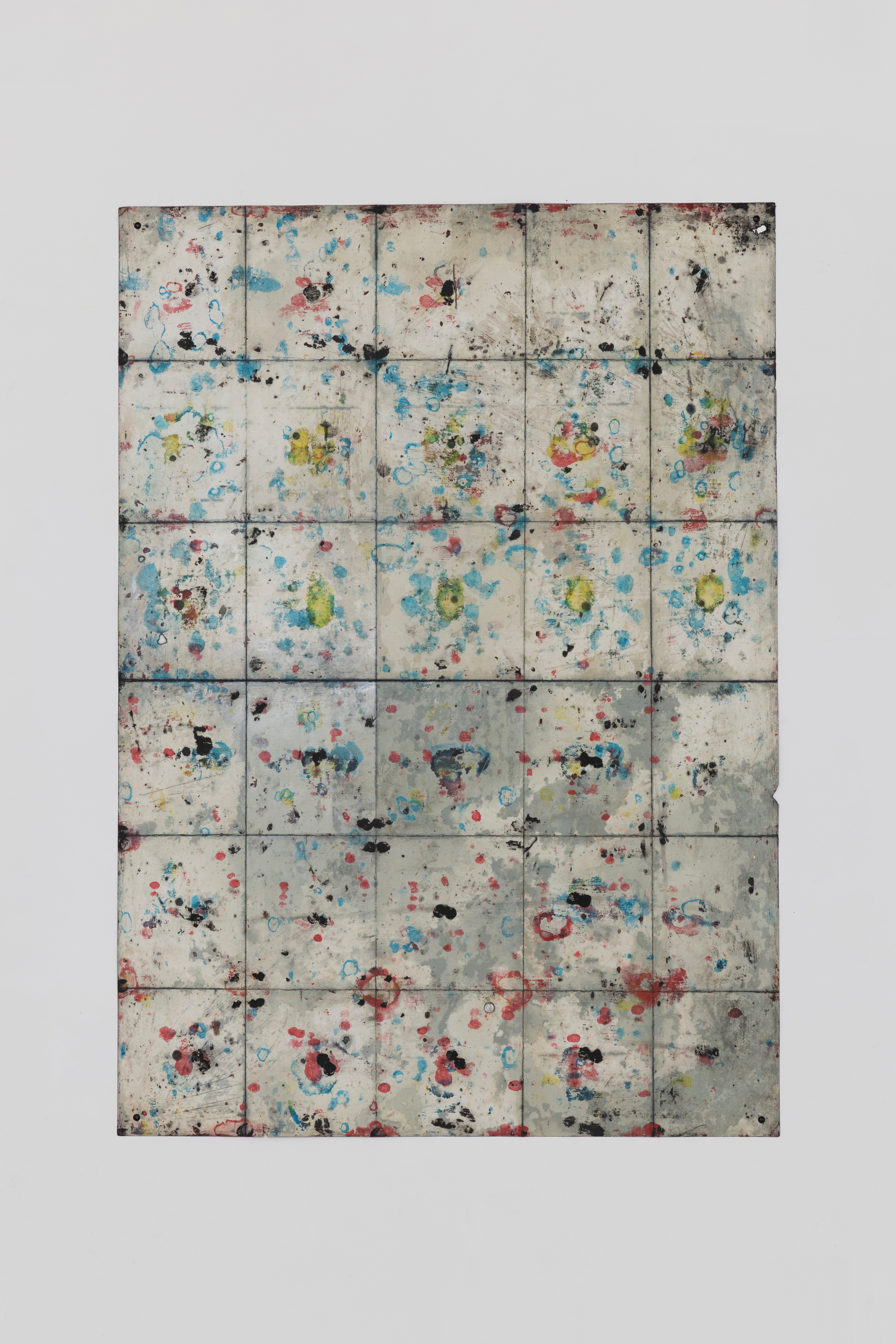 Anna Paterson's oil-on-paper panel work, its cream surface scattered with small marks in blue, red, yellow, and black across a grid of joins.