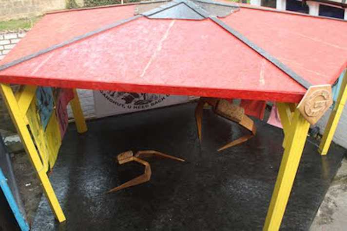 large yellow and red gazebo shot from above. there are artworks hung inside