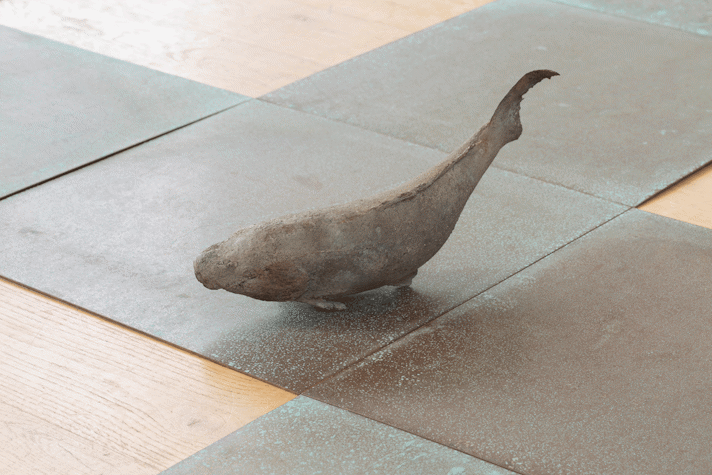 The floor is wooden and there are green coopper tiles. There is a bronze figure of a whale.
