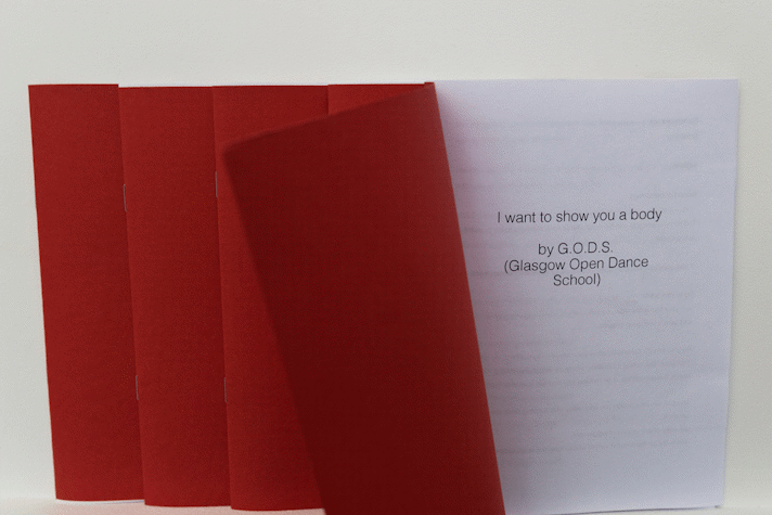 The red cover of an A5 publication is pulled back to show a cover page that reads 'I want to show you a body by G.O.D.S. (Glasgow Open Dance School)'