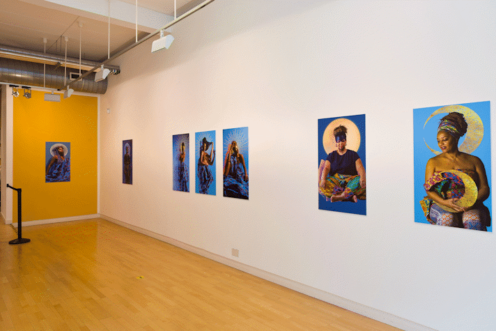 a series of portrait photographs hang in a large gallery room