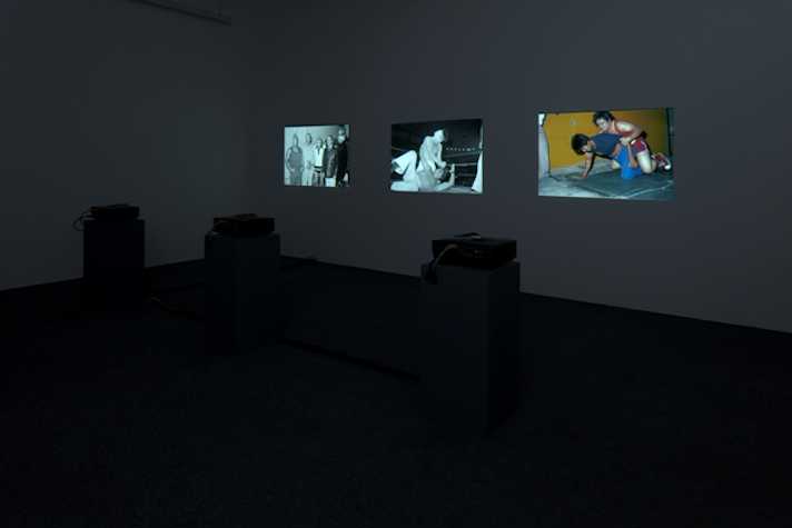 dark room with three images projected onto wall