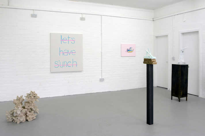 A white walled gallery with a number of artworks visible