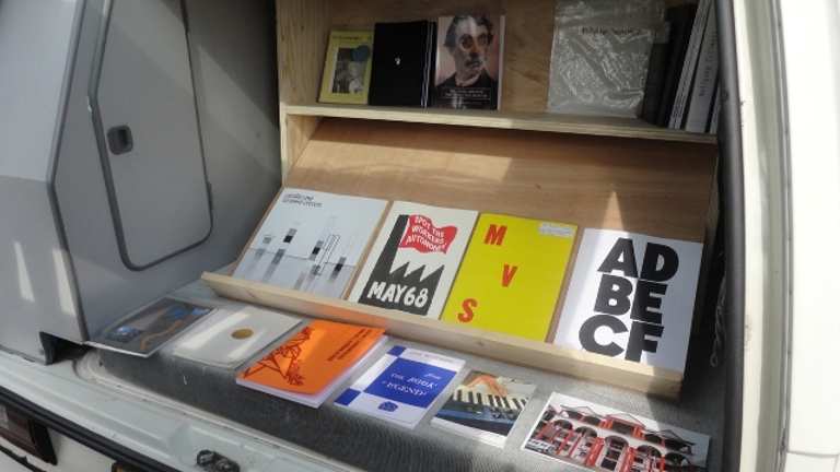 image of the back of the van which has shelves installed, displaying books