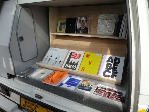 image of the back of the van which has shelves installed, displaying books