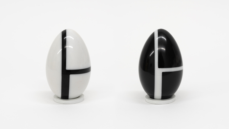  Two marble eggs on a white background, each rendered in black and white. Both share the same geometric pattern of two right angles, but the colours are reveresed: one egg is mostly black with white lines, the other mostly white with black lines.