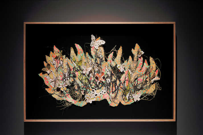 A black background with an collaged design flowers and butterflies within it.