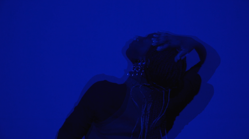 A blurred image of a person with their head thrown back, with a blue overlay.