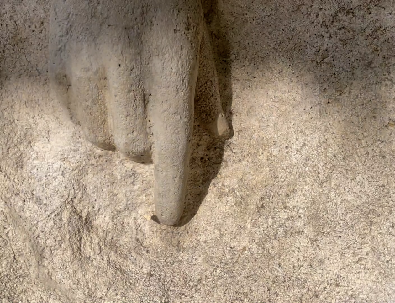A closeup image of a hand carved in stone