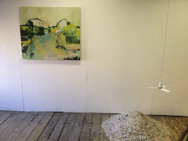 Installation view, painting on wall, small pile of rubble of floor, hanging fan
