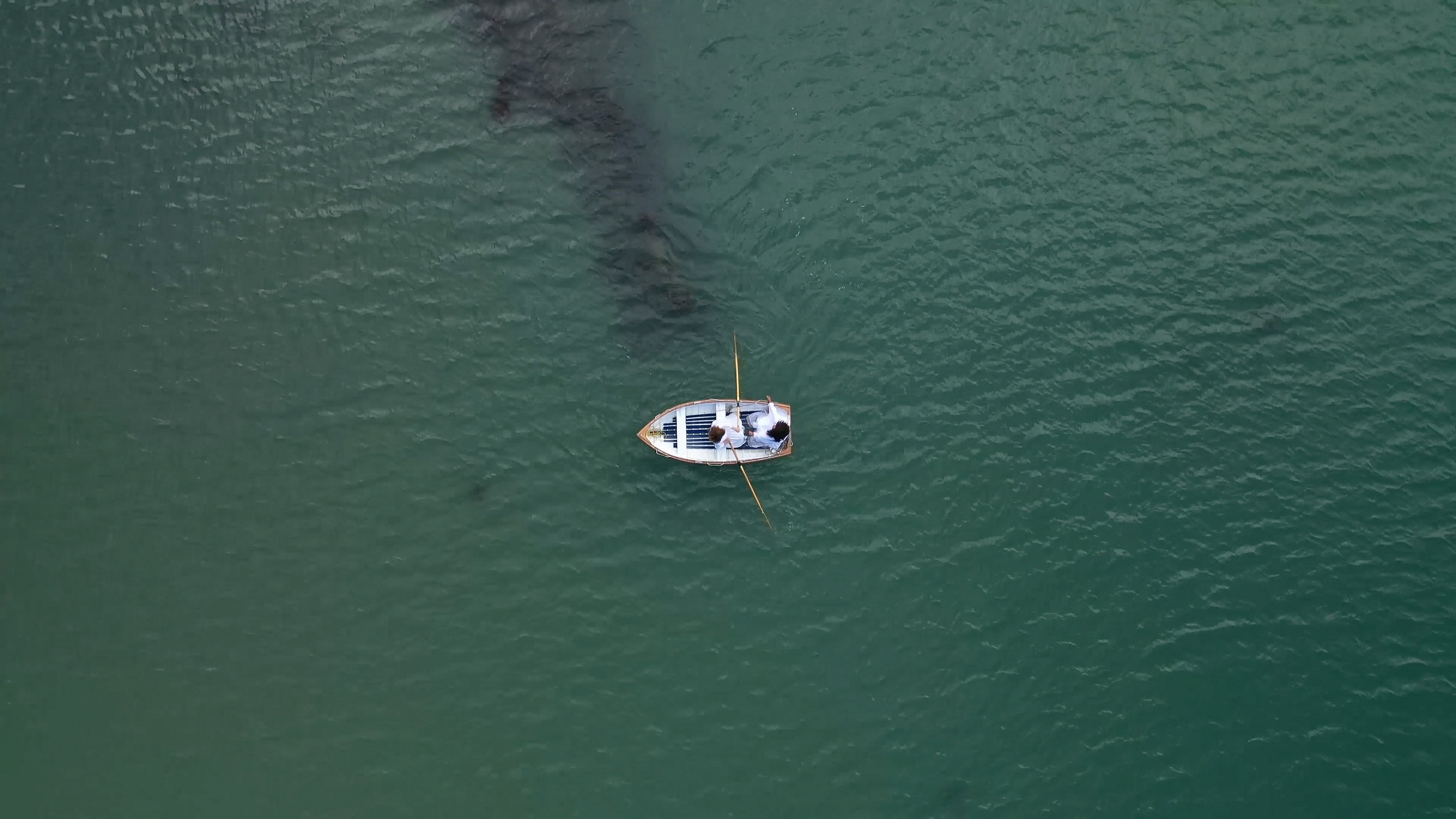 Film still showing an aerial shot of a boat in the sea