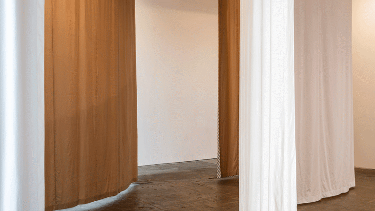 Brown and white curtains in a wavy shape as a part of Art installation in Tramway as part of Glasgow International 2018.