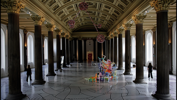 Interior view of Gallery of Modern Art, Glasgow showing a black and white striped floor, with coloured sculpture 