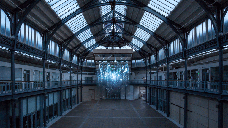 Interior of Briggait Hall with suspended video installation at dusk