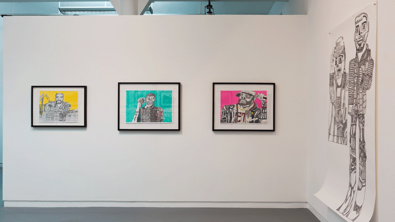 drawings hang on a gallery wall