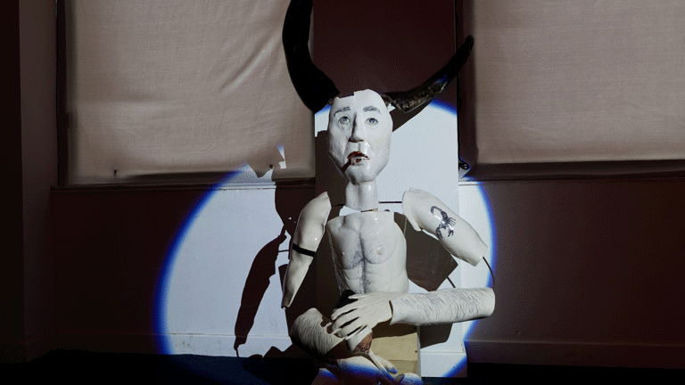 spotlit ceramic figure in dark room