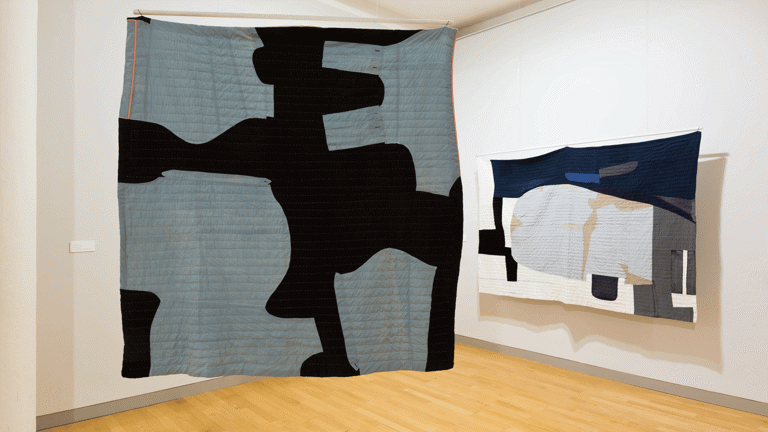 installation view image of large scale quilt hangings with abstract cut out shapes