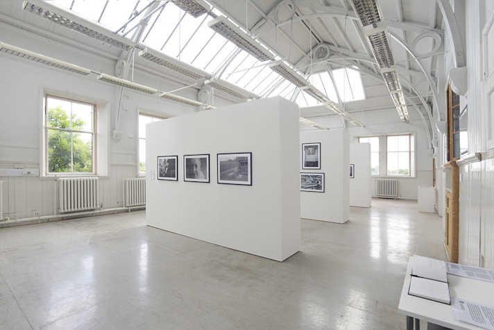 Framed photographs are displayed on white walls in a light and airy space.