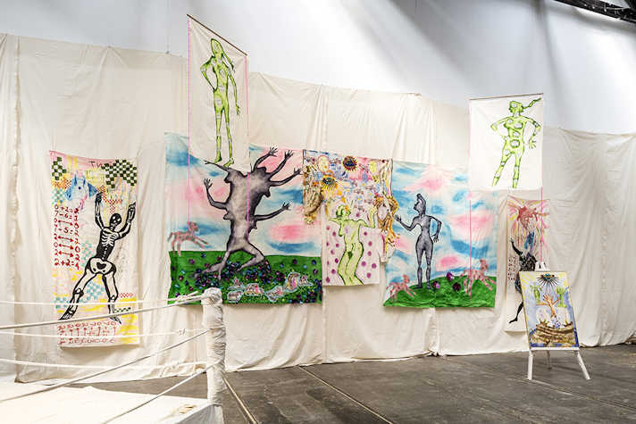 Artwork is displayed on a fabric wall hanging.