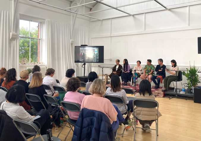 A panel discussion with six people speaking in front of a live audience