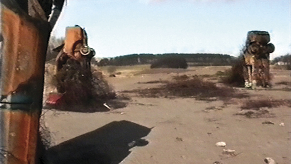 A landscape view with some up-turned cars buried in the sand