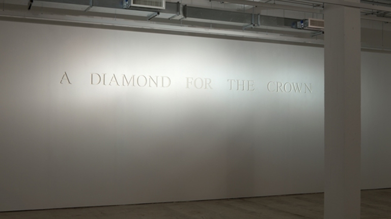 white wall with engraved text, 'A DIAMOND FOR THE CROWN'