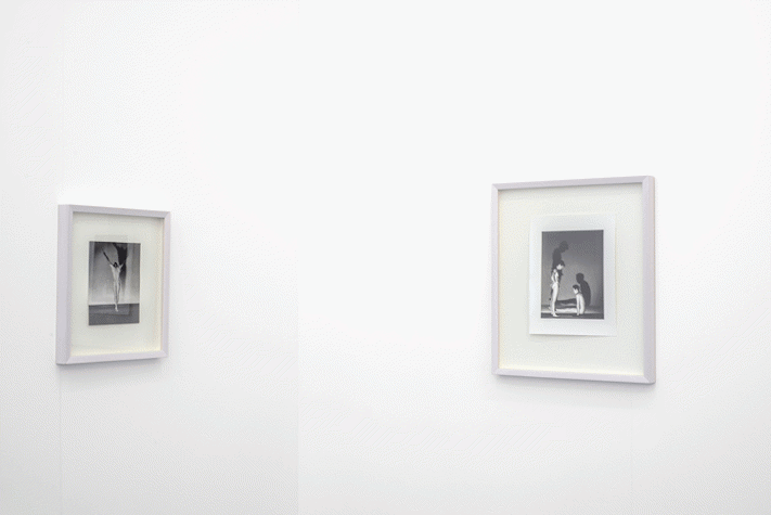 Two framed monochromatic photographs are placed in the corner, where two walls connect.