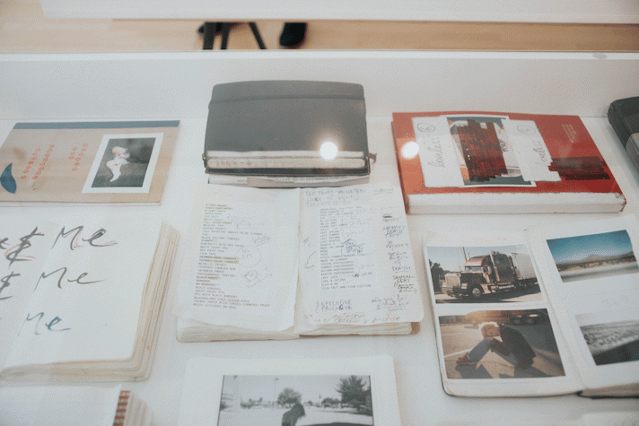 Close up view of documentation in a vitrine including notebooks and photographs