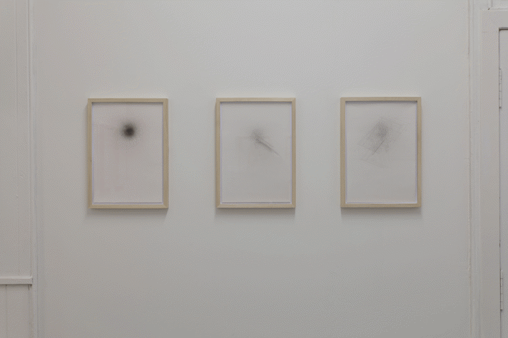 three framed technical drawings on a white wall.