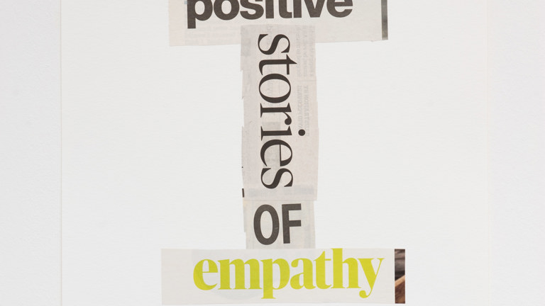 Collaged sections of newsprint with the words 'positive' 'stories' 'of' 'empathy'