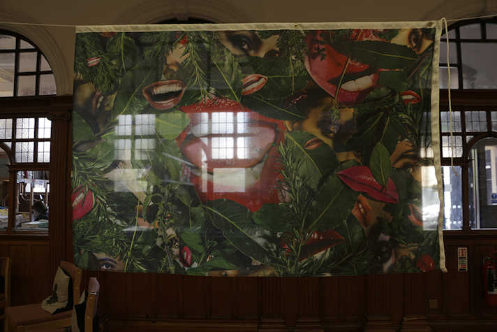 Commissioned flag hung in library's facade, drawing upon the feminist and pop culture artefacts in the library's collection