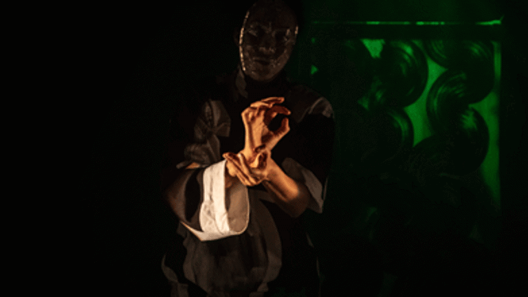 female performer, light focus on the hands in pose