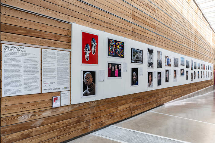 A row of images displayed on a long white board, on a wooden panelled wall.