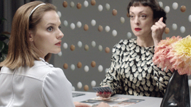 Installation shot showing film still of two women and a vase of flowers