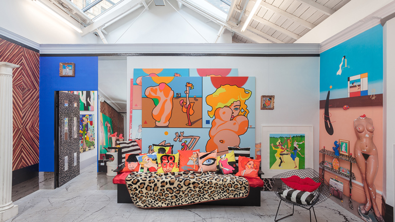 In a white art space with fluorescent light panels from the ceiling we can see a living room space, with a sofa with leopard print and pop-art cushions in the centre. It has an open door to the left leading to another room with colourful art. To the right in the wall a picture of a manequin and a modern colorful art background. There is also a chair with a red lip-shaped cushion.  The back wall has big colorful depictions of bodies and dancing people. 